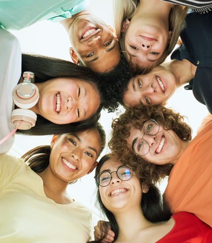 屋外のベンチで写真を撮る多国籍の仲間たち